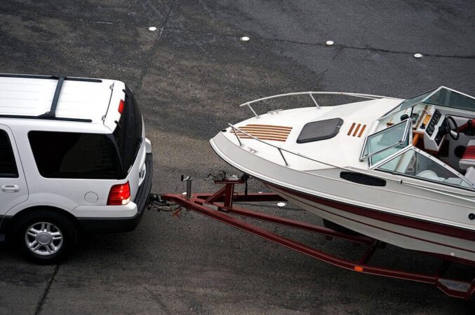 suv pulling white speed boat on trailer
